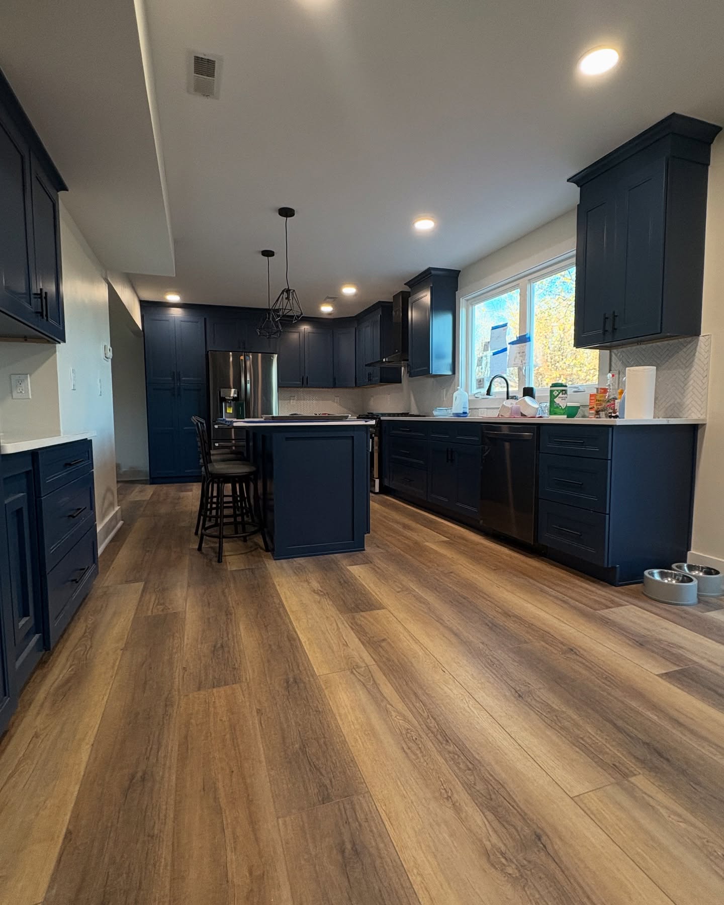 Kitchen hardwood flooring with navy cabinets