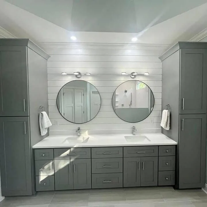 Double sink bathroom vanity installation in Washington Township with gray cabinets, white countertop, and round mirrors
