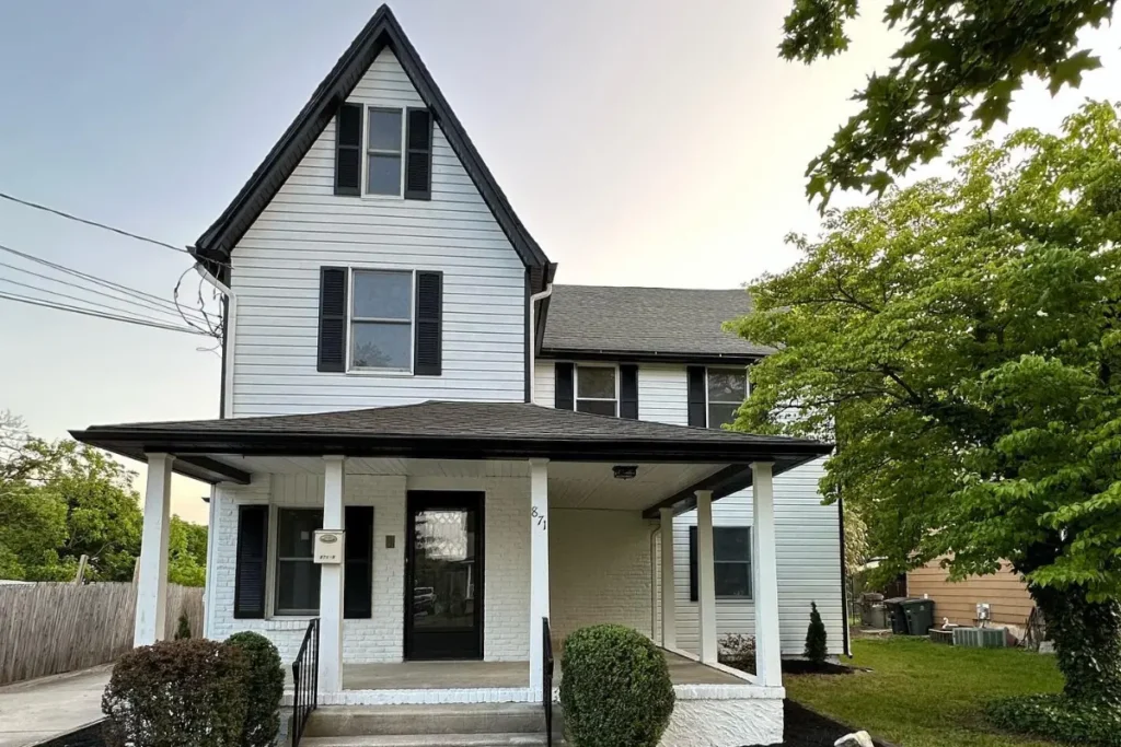 Freshly remodeled white two-story house with black trim, covered front porch, and manicured landscaping, highlighting Exterior Home Remodeling in Washington Township NJ.