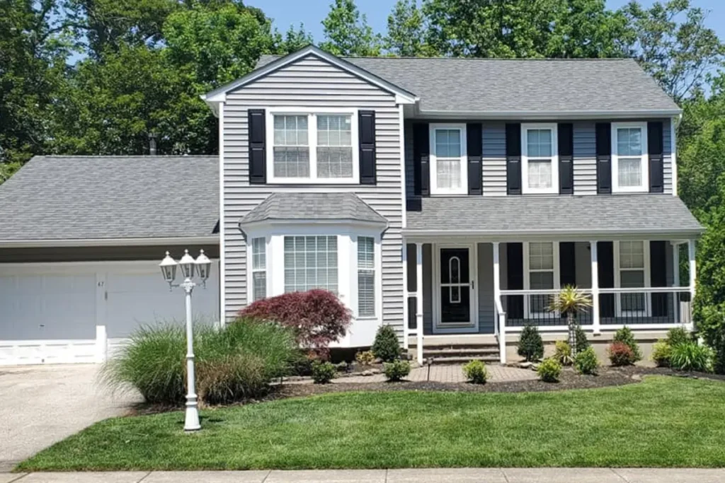 Beautifully renovated home exterior with gray siding and black shutters by a general contractor in Glassboro NJ.