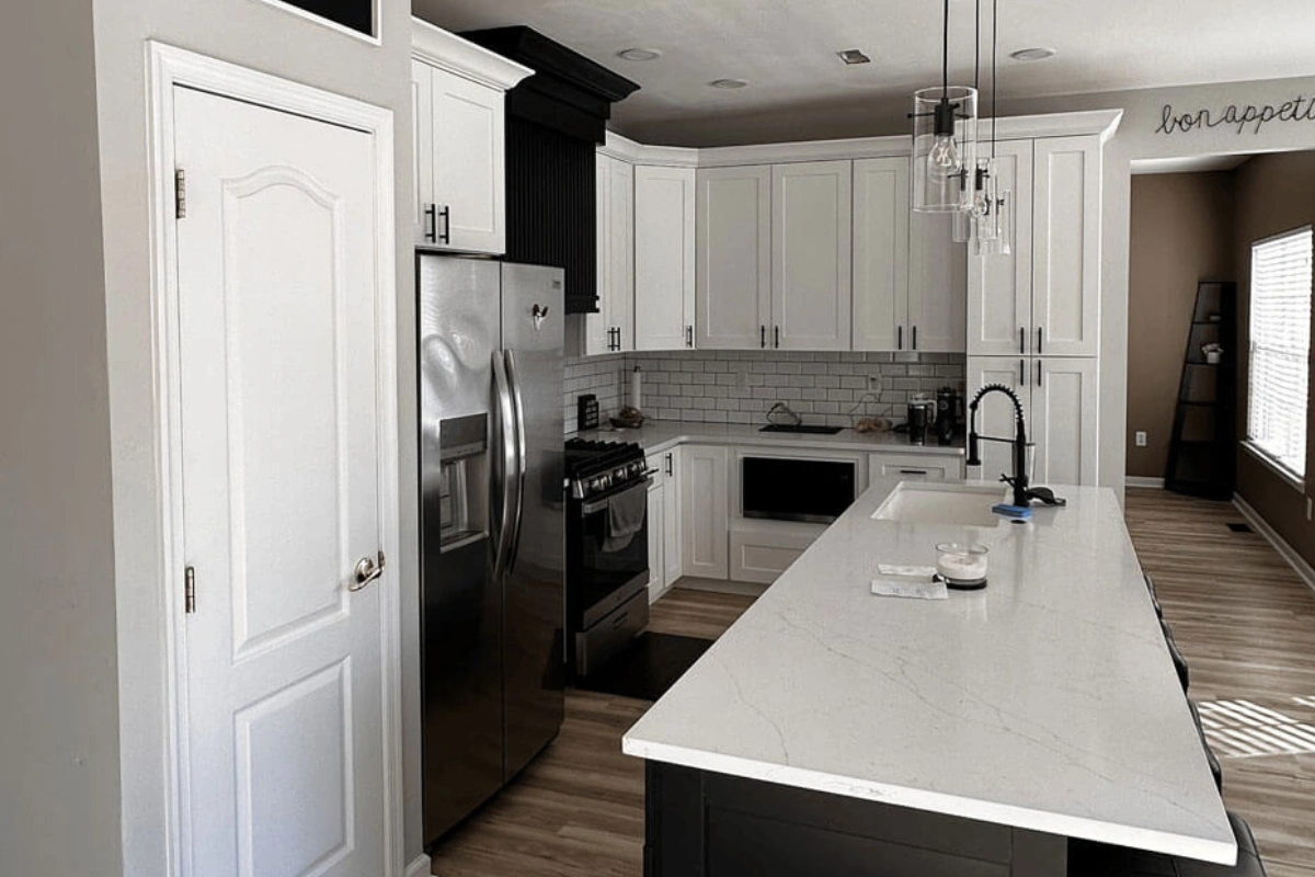 Updated Sewell NJ kitchen remodeling showcasing black and white cabinetry, stainless steel refrigerator, and open-concept layout