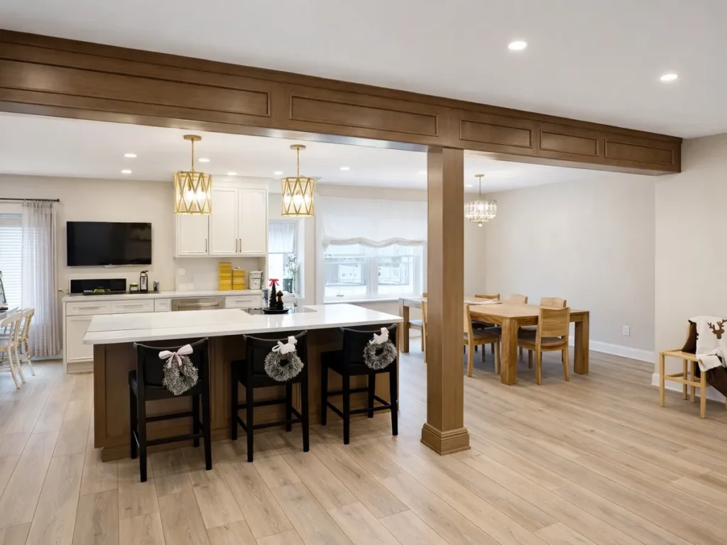 Open first-floor layout with exposed beam, kitchen island, and dining area in Somerton Philadelphia remodel