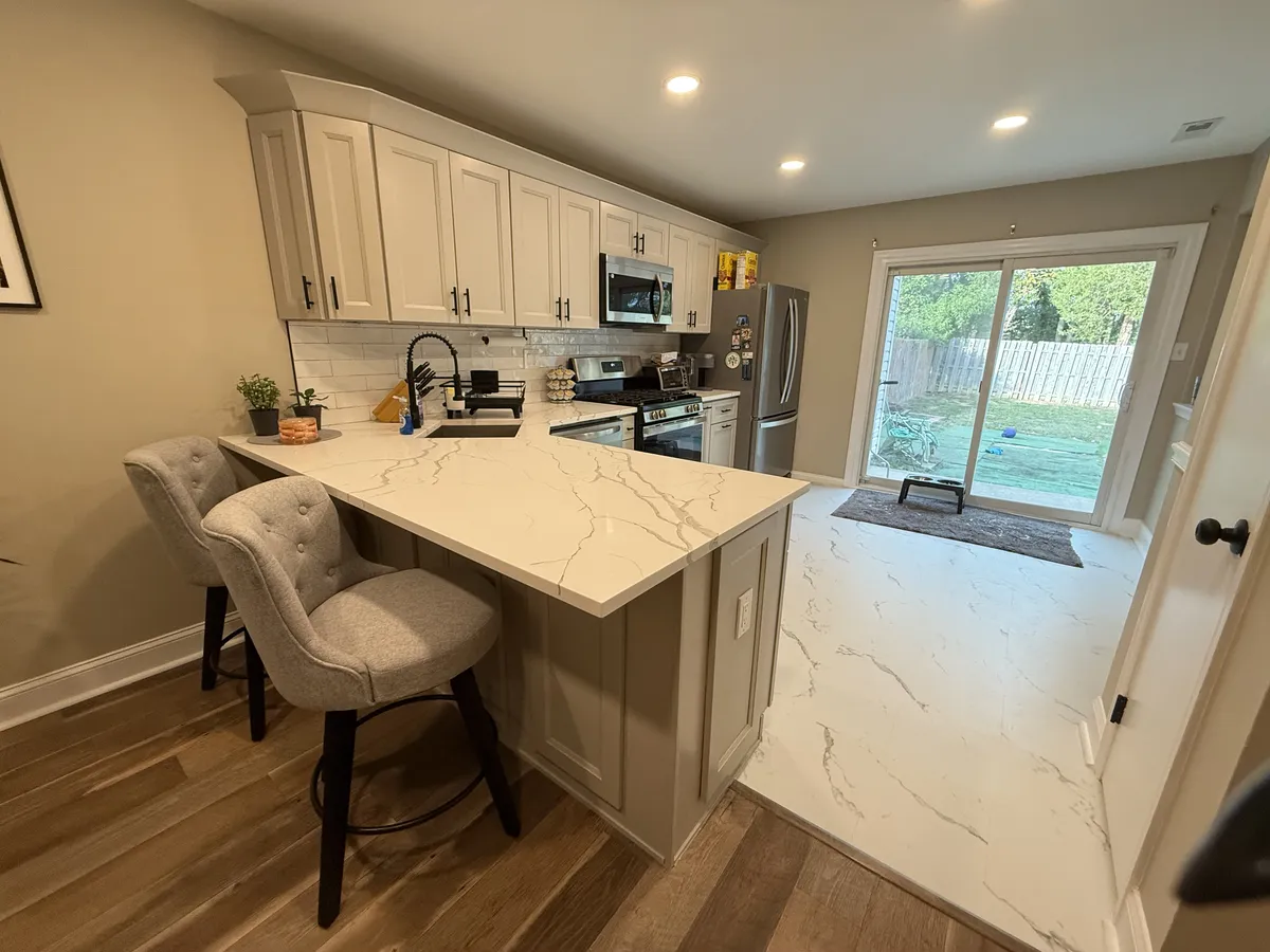 Kitchen peninsula with bar stool seating and hardwood floors