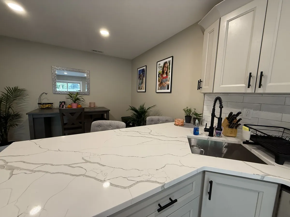 Quartz countertop with subway tile backsplash and black matte faucet