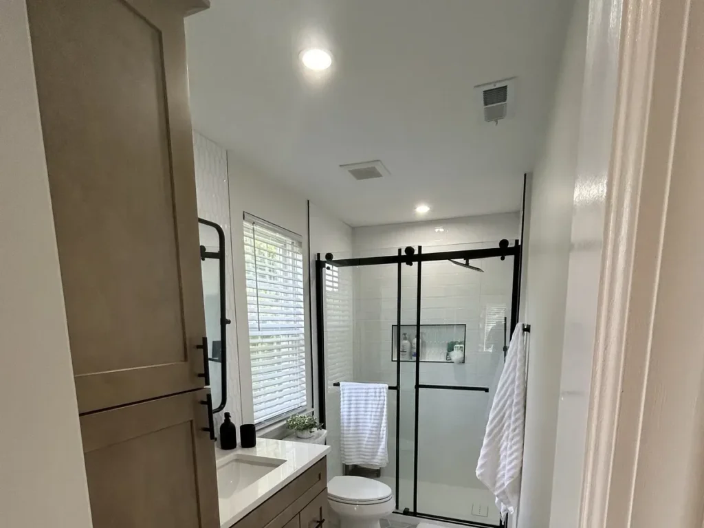 Full bathroom renovation showing wood vanity and glass shower enclosure in Philadelphia
