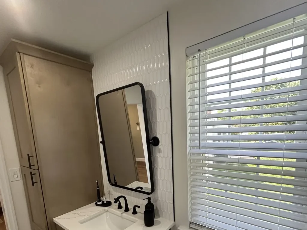 Wood-tone bathroom vanity with quartz countertop and black fixtures in Philadelphia