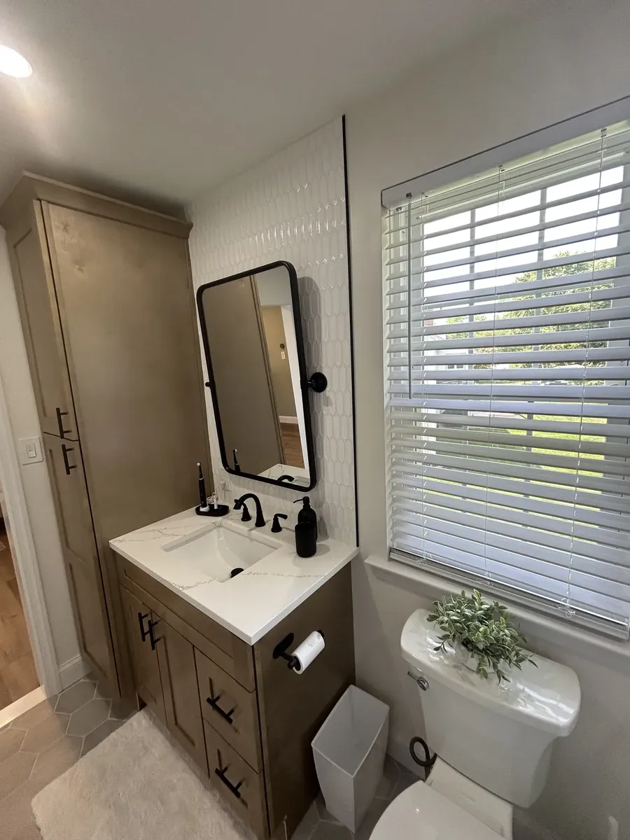 Wood vanity with a black framed mirror and white plank wall in Franklinville, Philadelphia