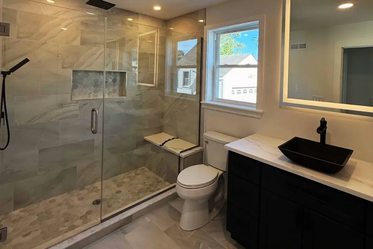 Large-format tile shower next to a dark vanity and window in Hunting Park, Philadelphia