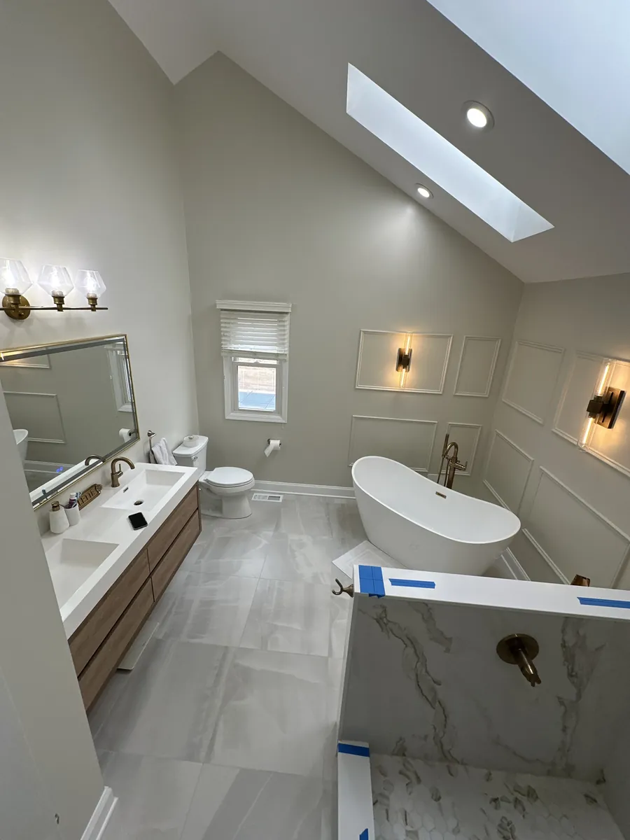 Vaulted bathroom with a skylight, soaking tub and wall sconces in Juniata Park, Philadelphia