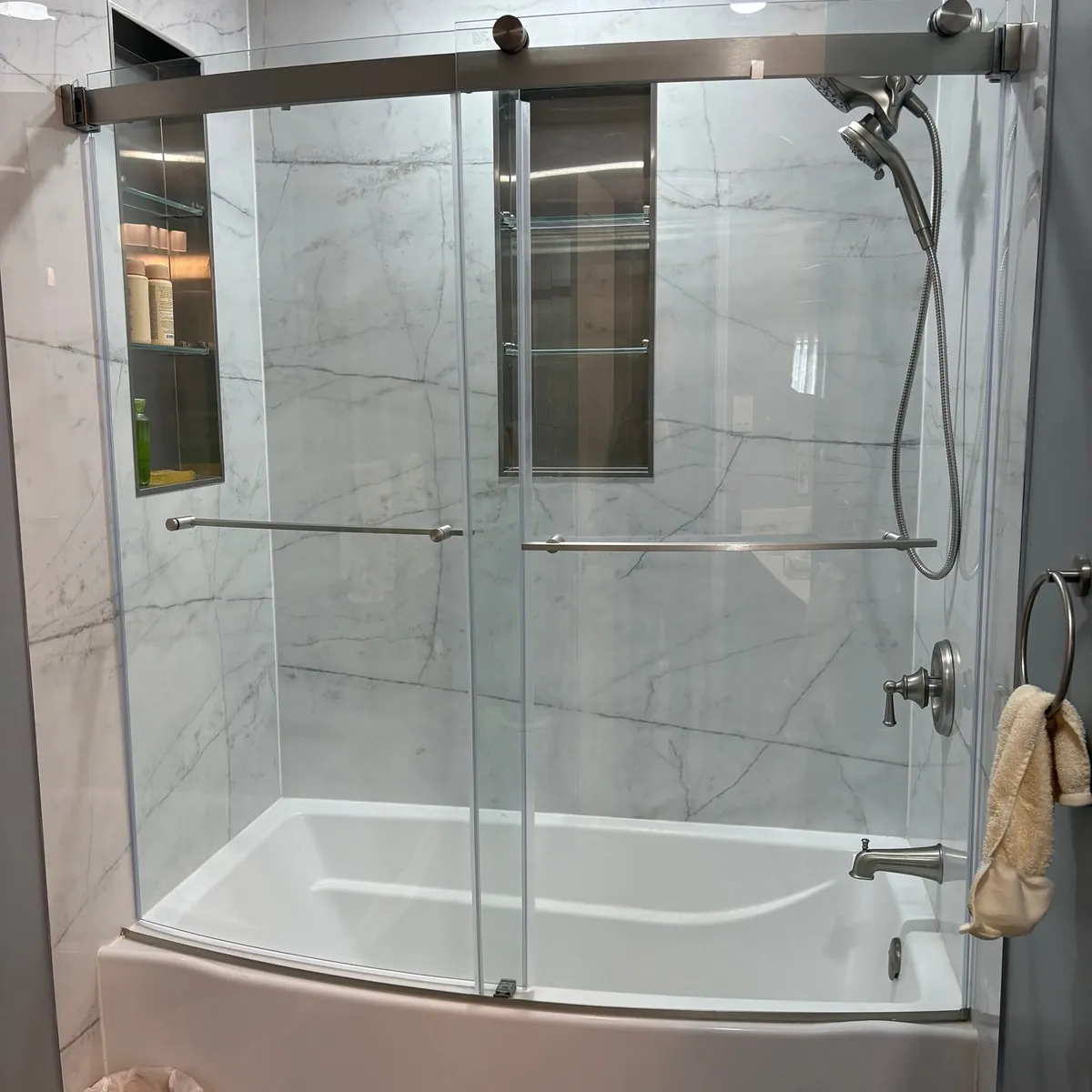 Curved-front tub with chrome sliding shower doors in General Pulaski Park, Philadelphia