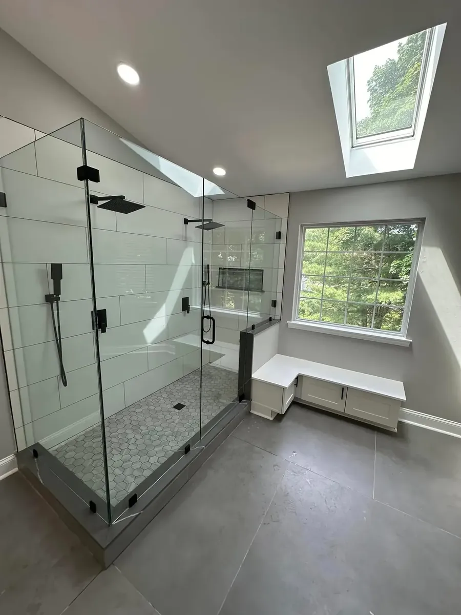 Corner glass shower with a tiled bench and skylight above in Port Richmond, Philadelphia