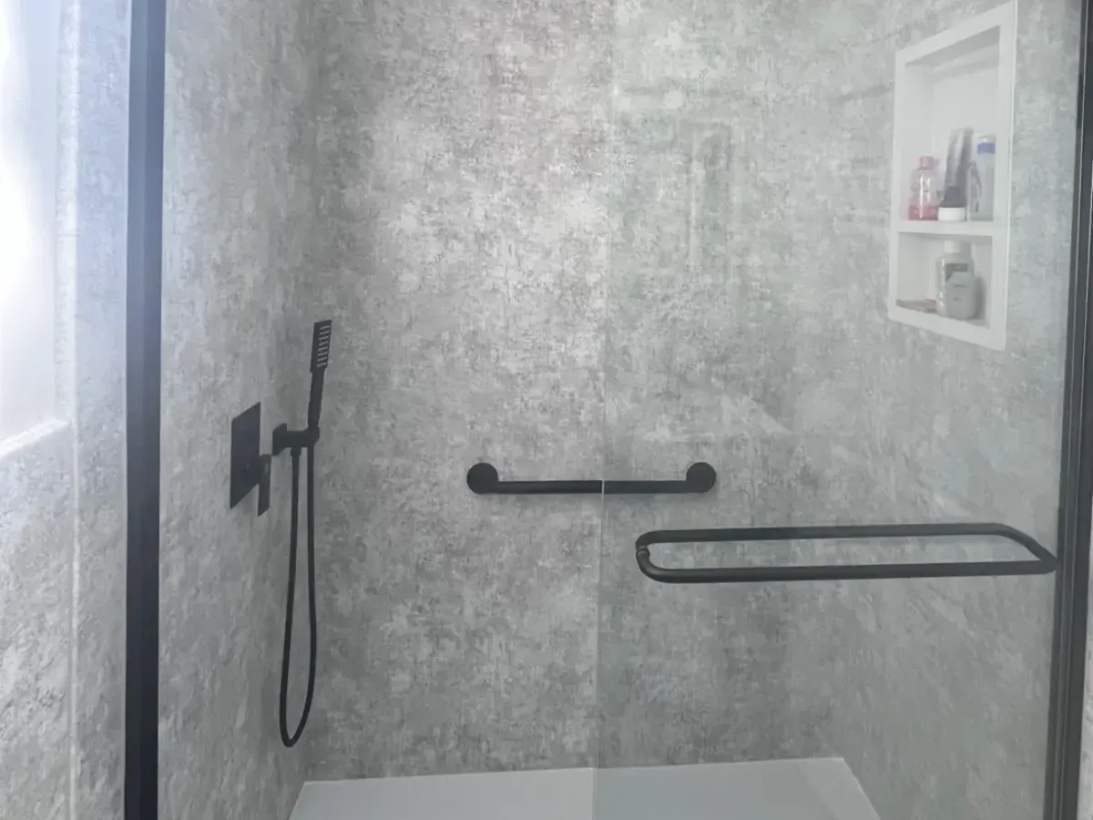 Stone-look shower panels with black grab bars in Port Richmond, Philadelphia
