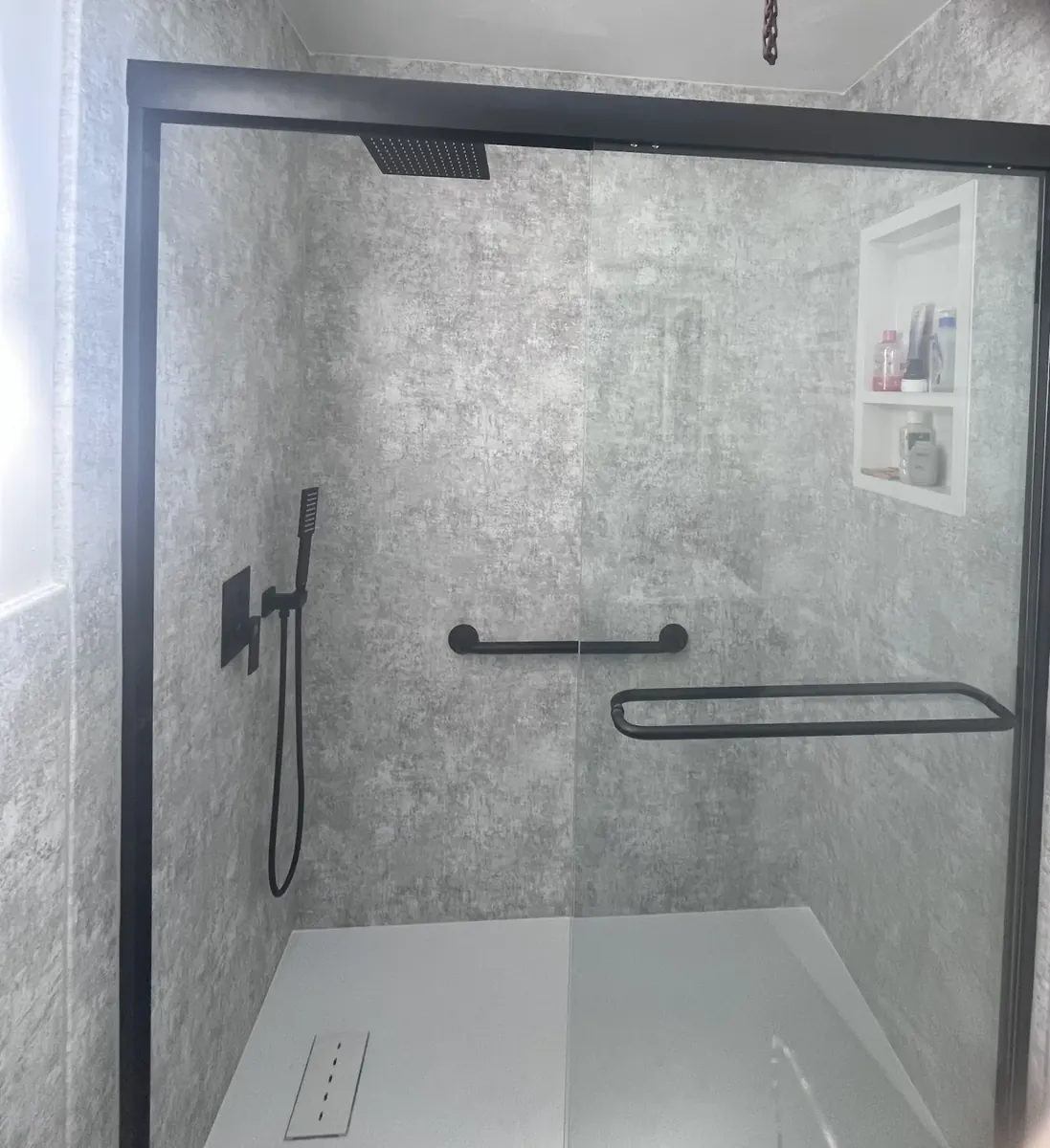 Walk-in shower lined with stone-look wall panels in Sharswood, Philadelphia