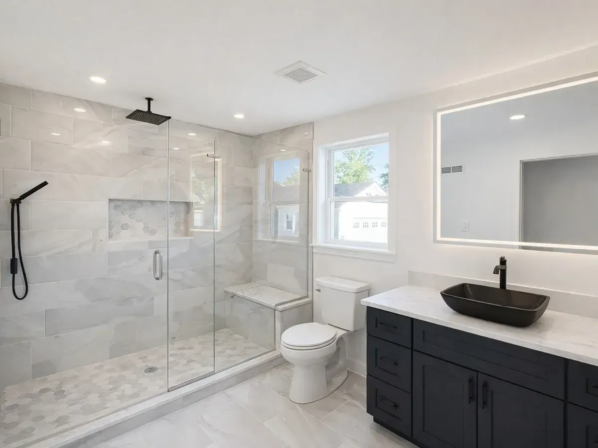Marble tile shower with a bench beside a dark vanity in Strawberry Mansion, Philadelphia