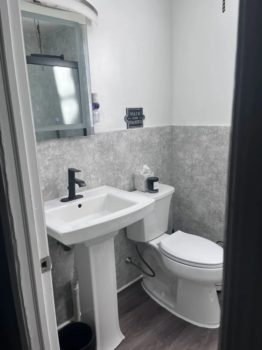 Small powder room with a pedestal sink and framed mirror in West Kensington, Philadelphia