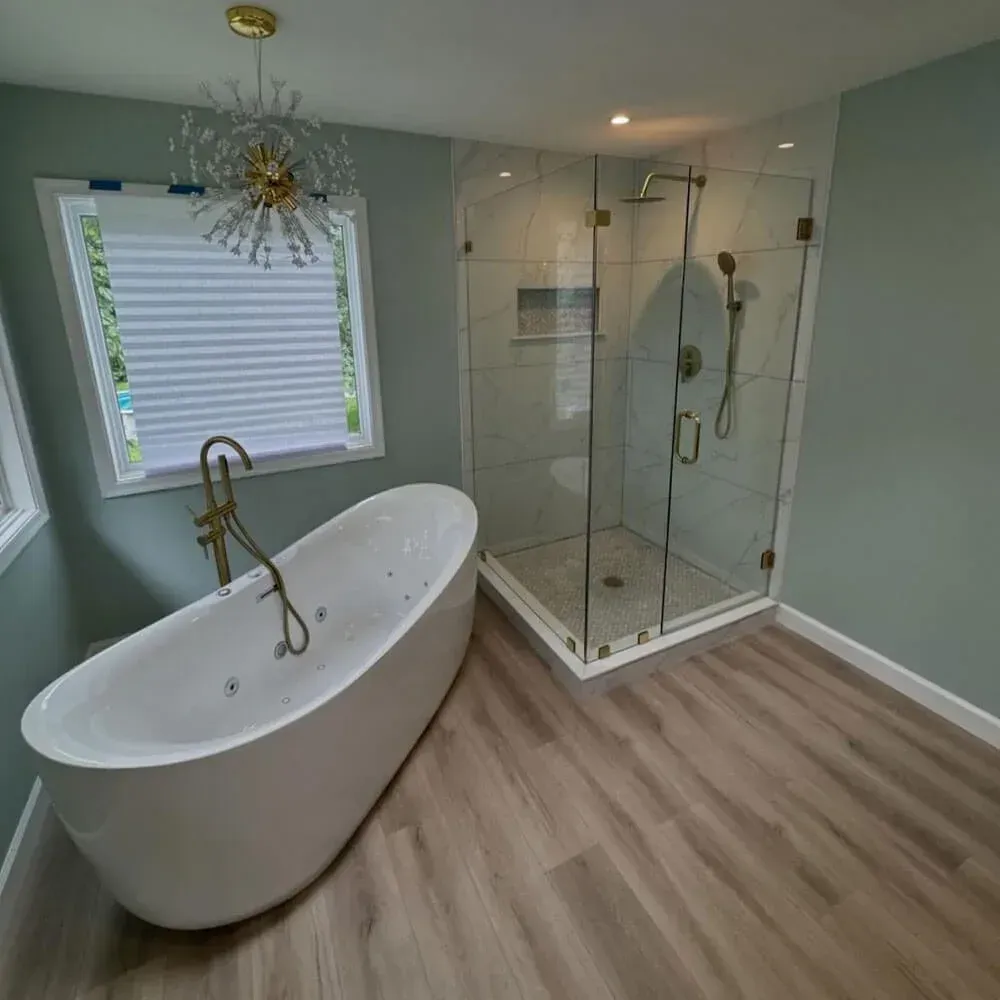Bathroom with wood-look tile flooring ready for radiant heat, a freestanding tub and a glass shower