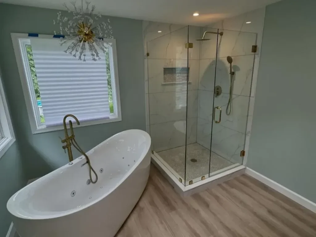 Master bathroom remodel with a freestanding soaking tub, corner frameless glass shower and wood-look floor
