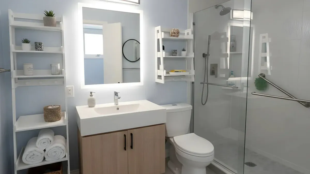 Small bathroom remodel with a light wood vanity, lighted mirror, glass shower and open shelving