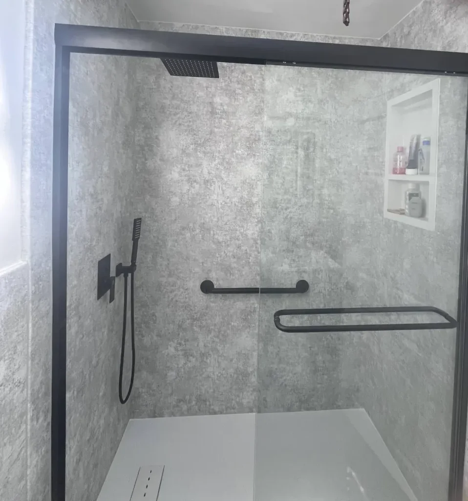 Step-free shower with a low-profile base, grab bar and large concrete-look wall panels