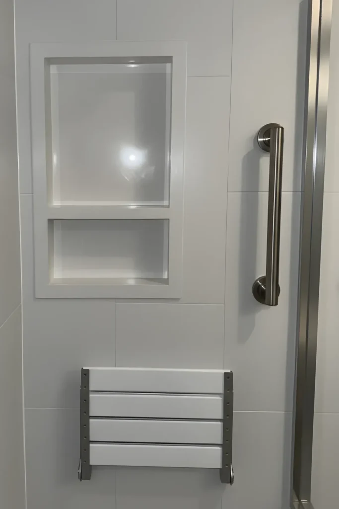 New shower wall after demolition and rebuild with a recessed niche, grab bar, and fold-down seat
