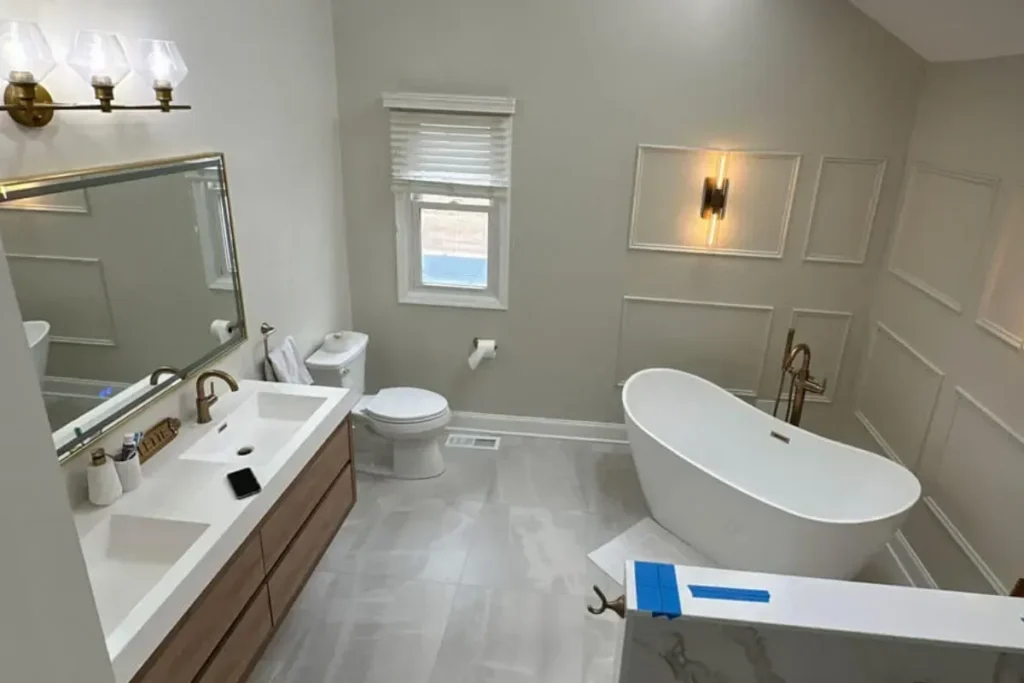 Bathroom remodel in progress with a new freestanding tub, floating wood vanity and panel walls