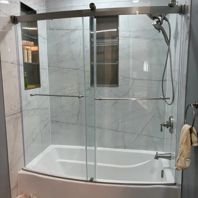 Updated tub and shower with sliding glass doors and marble-look wall panels