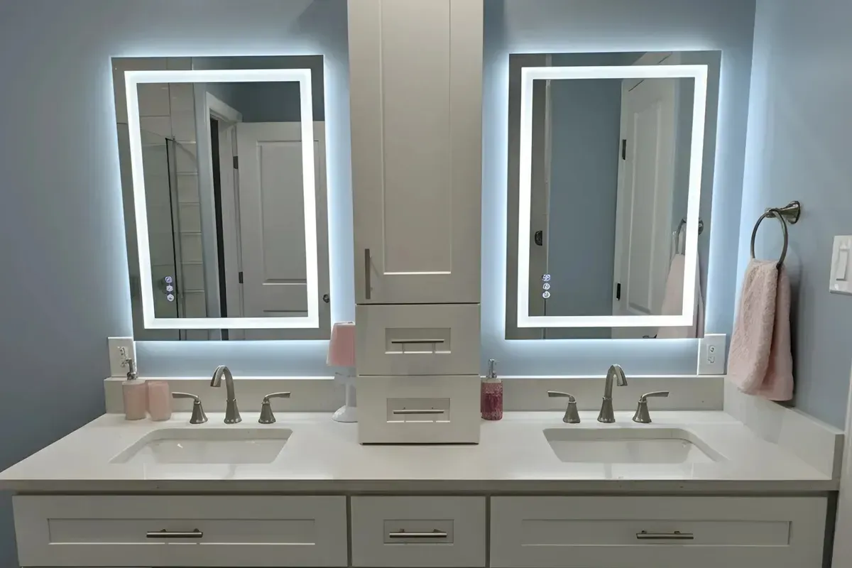 White double vanity with two backlit LED mirrors and a center storage tower