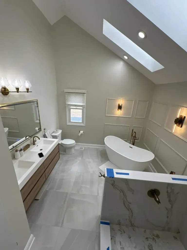Remodeled bathroom with a vaulted ceiling, skylight and freestanding soaking tub