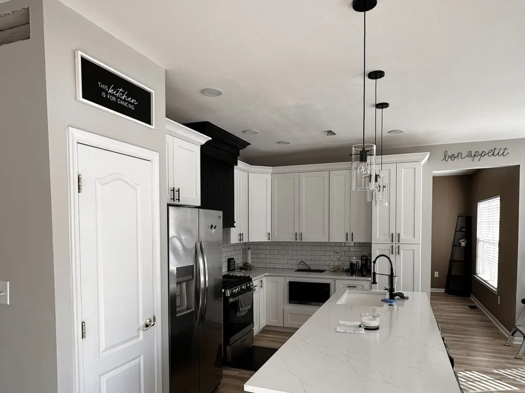 White cabinets, a long quartz island and pendant lights in a Philadelphia custom kitchen design
